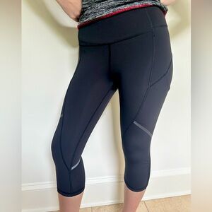 Lulu Lemon cropped legging with reflective strip and mess bottom. Size 4.